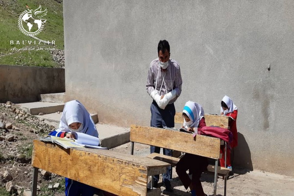 تدریس معلم فداکارهرسینی در استان کرمانشاه بادست‌های شکسته در حال تدریس