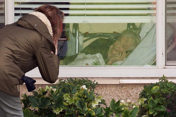 عکس/حرف زدن دختر با مادر کروناگرفته‌اش از پشت پنجره